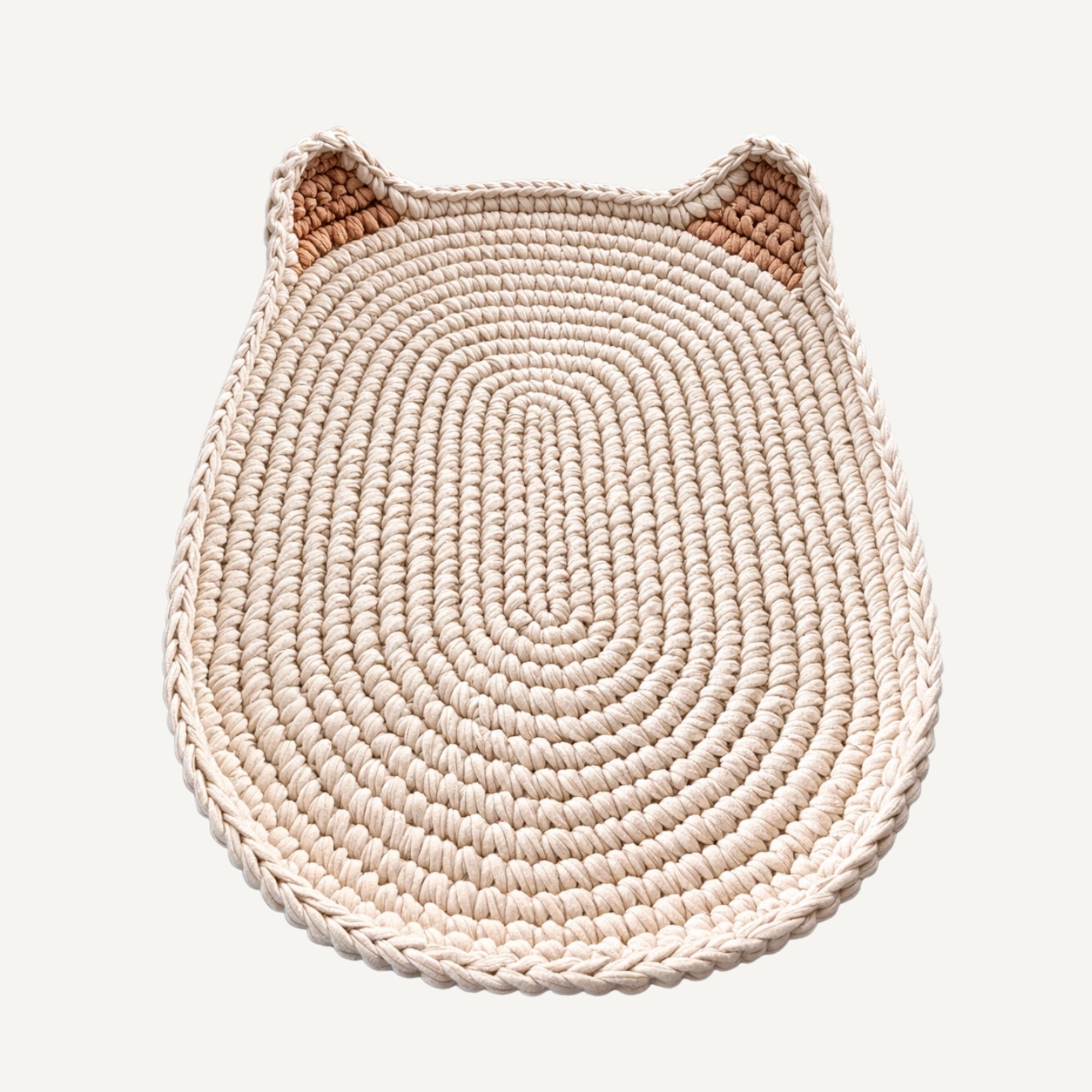 A woven cat-shaped rug in a light cream color with slightly darker tan inner ears, shown on a solid off-white background.
